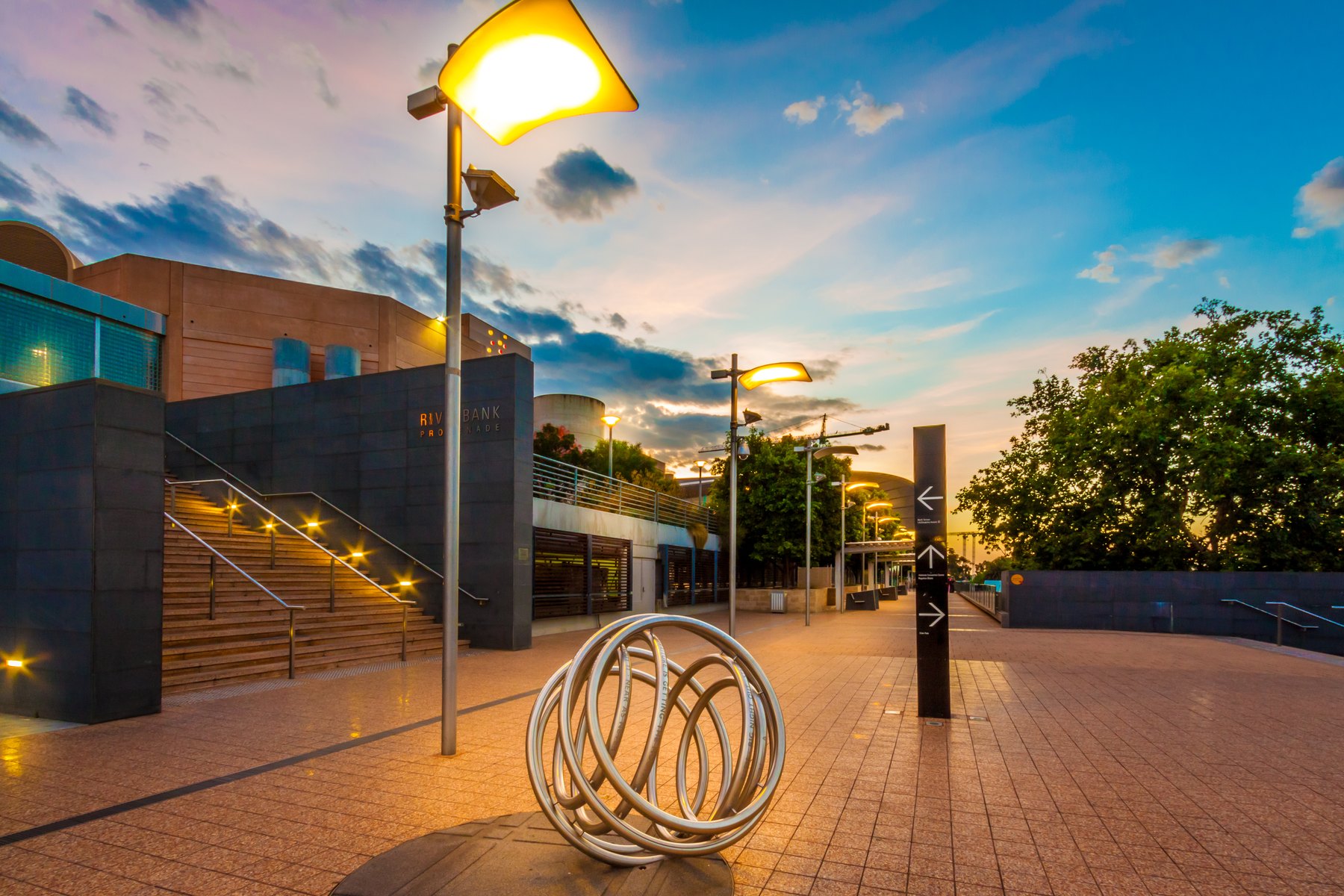 Pole lights along a promenade at dusk