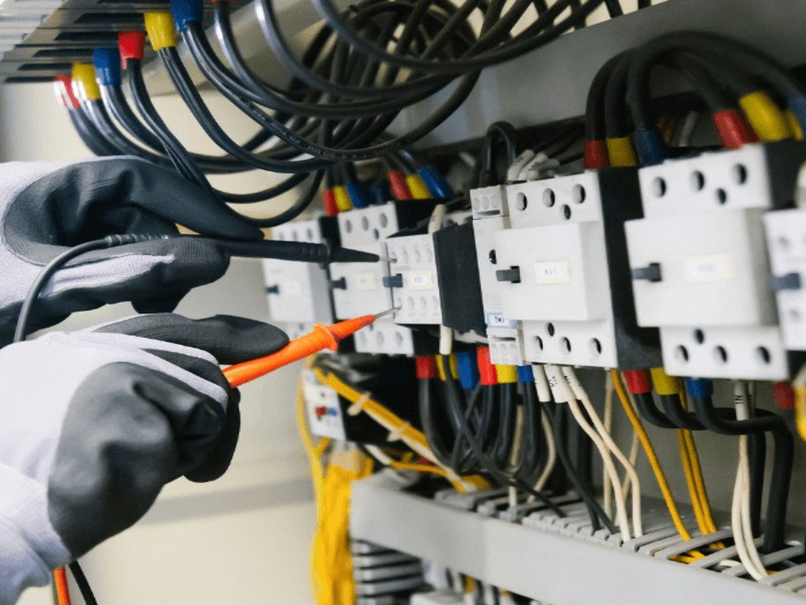 Electrician testing a breaker panel with a meter to find the real fault