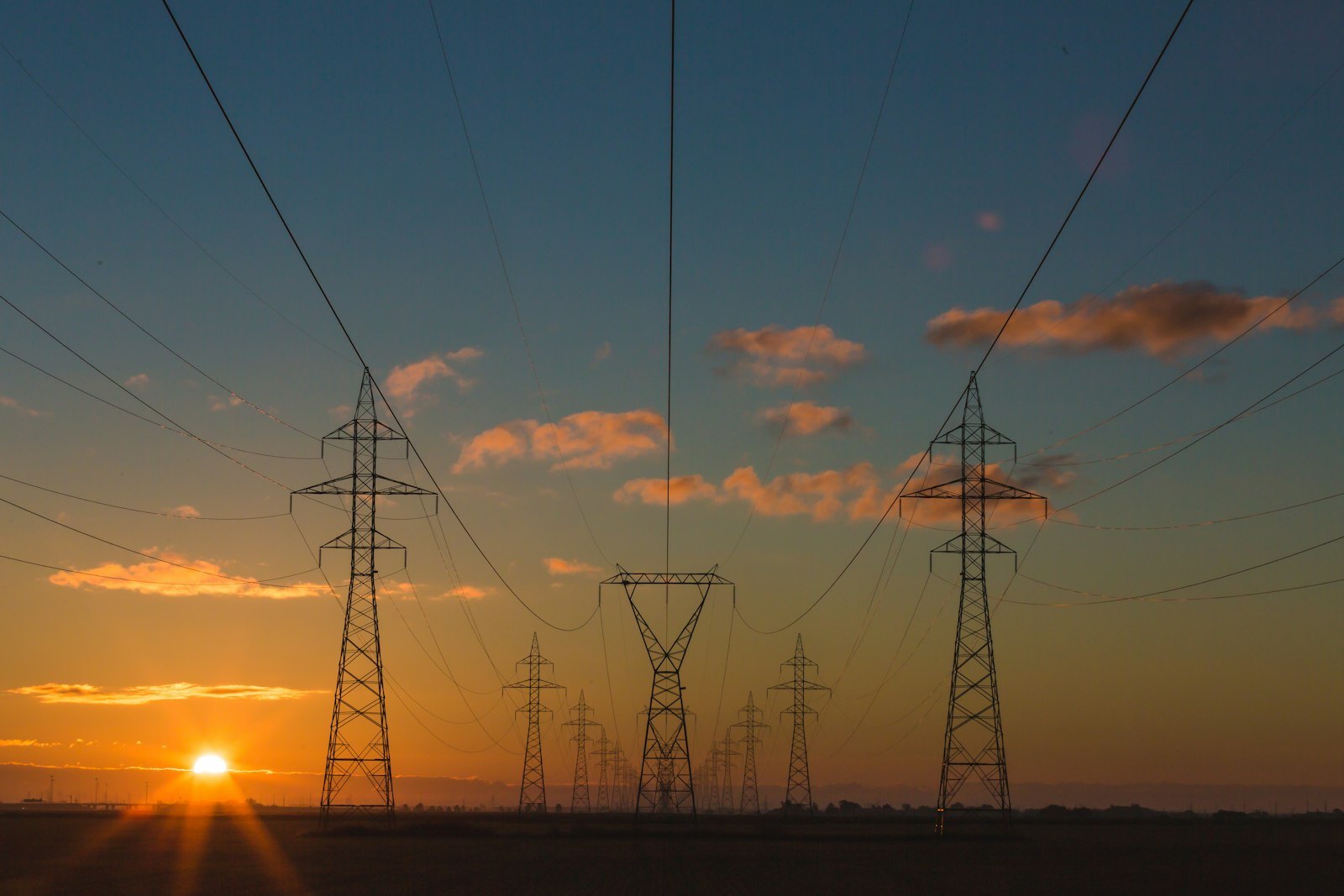 Transmission lines at sunset — the grid side of a surge event