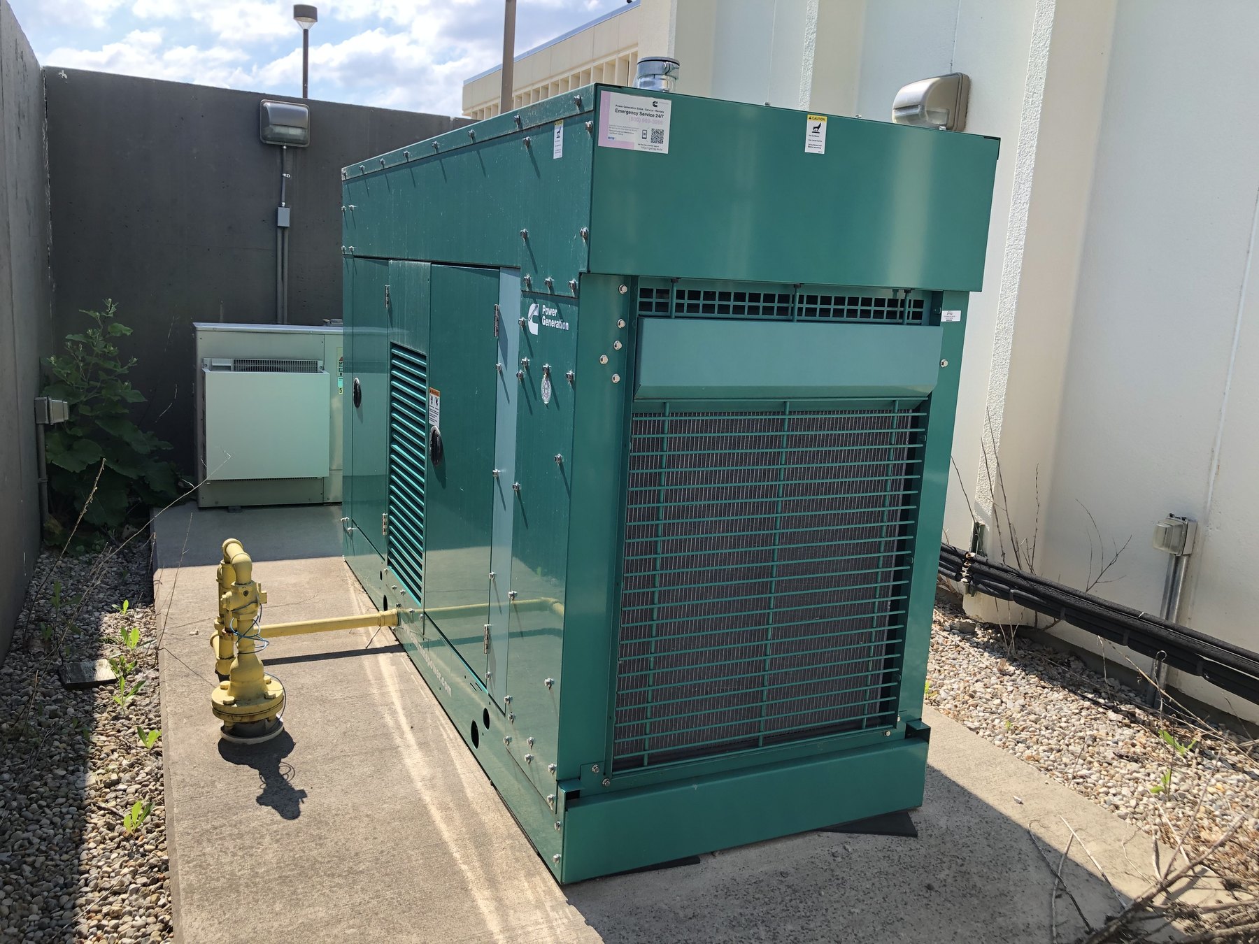 Standby generator on a concrete pad, ready for a transfer-switch connection